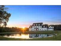 Stunning exterior view of a two-story home reflected on a pond during sunset at 4510 Packard S Ave, St Cloud, FL 34772