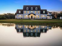 Elegant two-story home with a pond reflection at 4510 Packard S Ave, St Cloud, FL 34772