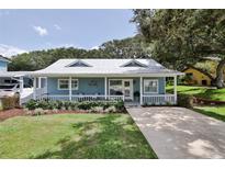 Quaint light blue house with a front porch and lush green lawn at 801 E 8Th Ave, New Smyrna Beach, FL 32169