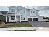 Two-story home featuring a light gray exterior, a brick paved driveway, and an attached two-car garage at 2726 Ravencliffe Ter, Oviedo, FL 32765