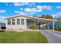 Single-wide manufactured home with carport and landscaped yard at 6375 Lolly Bay Ne Loop, Winter Haven, FL 33881