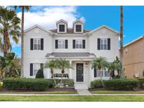 Two-story house with a front porch and landscaping at 7400 Soiree Way, Reunion, FL 34747