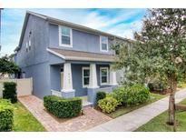 Two-story house with blue exterior, front porch, and landscaped yard at 8329 Lookout Pointe Dr, Windermere, FL 34786