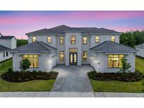 Stunning two-story home featuring a symmetrical facade, attached garages, and professional landscaping at 9847 Laurel Berry Dr, Orlando, FL 32827