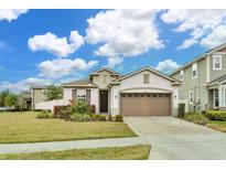 Charming one-story home with a two-car garage, landscaping, and a lush green lawn at 2232 Donahue Dr, Ocoee, FL 34761