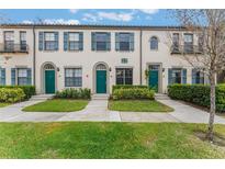 Three-unit townhouse building with green doors and landscaping at 711 Centervale Dr # 711, Celebration, FL 34747