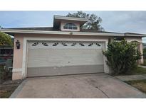 Exterior image of the garage featuring a beige door with windows on a single-story home at 770 Mink Ct, Poinciana, FL 34759