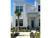 Modern two-story house with gray stone accents and palm tree landscaping at 1431 Serendipity Ln, Clermont, FL 34714