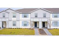 Two-story townhouses with gray siding, blue shutters, and landscaped lawns at 4298 Lana Ave, Davenport, FL 33897