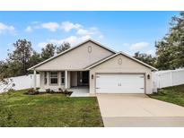 Charming single-story home with a two-car garage, well-maintained lawn and an attractive neutral exterior paint scheme at 10339 Castillo Ct, Clermont, FL 34711