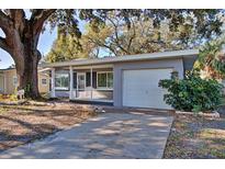 Charming ranch home with screened porch, large oak tree, and spacious driveway at 1246 Margina Ave, Daytona Beach, FL 32114