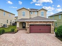 Two-story house with a red door and brick driveway at 211 Pendant Ct, Kissimmee, FL 34747