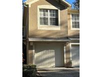 Tan two-story townhome with a two-car garage and large window at 2579 San Tecla St # 105, Orlando, FL 32835