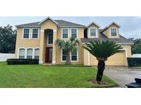Two-story house with a large front yard, attached garage, and palm tree at 357 Lake Amberleigh Dr, Winter Garden, FL 34787
