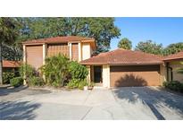 Exterior view of a two-story house with a brown tile roof and attached garage at 5019 Nassau Cir # 5, Orlando, FL 32808