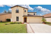 Two-story house with attached garage and landscaped lawn at 533 Woods Landing Dr, Minneola, FL 34715