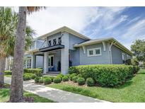 Curb appeal abounds in this beautiful 2-story home, featuring a landscaped yard and inviting front porch at 7901 Dausset St, Orlando, FL 32827
