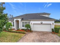 House exterior featuring a two-car garage and well-manicured landscaping at 9007 Eagle Cove Ct, Orlando, FL 32825