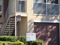 Building exterior featuring a brown garage door and second-floor balcony with metal railing at 12216 Wild Iris Way # 112, Orlando, FL 32837