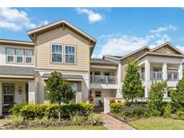 Inviting two-story townhome featuring a private balcony, landscaped yard, and charming walkway at 13444 Stoddart Ave, Orlando, FL 32827