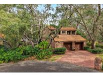 Charming two-story home featuring a brick facade, tile roof, and a two-car garage with mature landscaping at 136 Woodmill Rd, Longwood, FL 32779