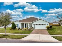 Charming single-story home featuring a well-manicured lawn, neutral exterior paint, and a two-car garage with driveway at 306 Quarry Rock Cir, Kissimmee, FL 34758