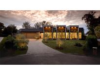 Modern home with a sleek design, landscaped yard, and a paved driveway at 8968 Bay Cove Ct, Orlando, FL 32819