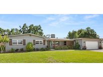 Charming single-story home boasts lush landscaping, a brick facade and a detached two-car garage at 1792 Killarney Dr, Winter Park, FL 32789