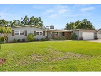 Charming one-story home with gray brick, brown trim, a spacious lawn, and mature trees at 1792 Killarney Dr, Winter Park, FL 32789