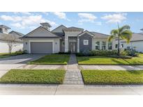 Beautiful two-story home with gray siding, tile roof, and a landscaped lawn at 193 Hampton Loop, Davenport, FL 33837