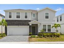 Charming two-story home with a stone facade, paver driveway and well-manicured landscaping at 1986 Summer Dr, Davenport, FL 33897