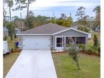 Newly constructed home with gray exterior, white garage door, and landscaped yard at 2016 West Pkwy, Deland, FL 32724