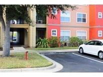 Exterior view of building, showing walkway and parking at 2216 Grand Cayman Ct # 1415, Kissimmee, FL 34741