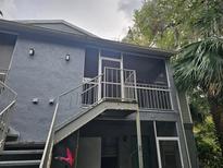 Exterior view of a two-story condo showing stair access to a screened porch with aluminum railings at 306 Northlake Dr # 306, Sanford, FL 32773