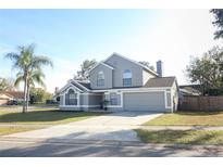 Two-story house with gray siding, landscaped lawn, and a two-car garage at 3473 Hillmont Cir, Orlando, FL 32817