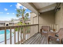 Relaxing balcony with wicker chairs overlooking the community pool at 425 Wymore Rd # 203, Altamonte Springs, FL 32714