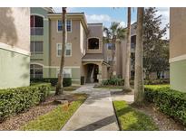 Exterior view of condo building with walkway and landscaping at 4897 Cypress Woods Dr # 6303, Orlando, FL 32811