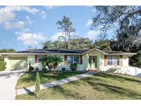 Ranch style home with green exterior, landscaped lawn, and attached garage at 109 Wynot Way, Deland, FL 32724