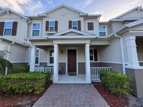 Inviting 2-story townhome with a charming front porch and landscaped walkway at 13731 Bravante Aly, Windermere, FL 34786