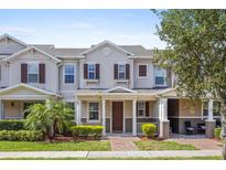 Charming townhome featuring a cozy front porch and beautiful landscaping in a well-maintained community at 13731 Bravante Aly, Windermere, FL 34786