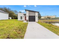 Modern house exterior with driveway and landscaped lawn at 3065 Jon Jon Ct, Orlando, FL 32822