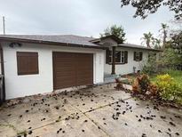 Newly painted single story home with a brown garage door and manicured landscaping at 4249 Kendrick Rd, Orlando, FL 32804