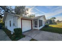 White single-story house with a garage and screened porch at 436 Avenue G Se, Winter Haven, FL 33880