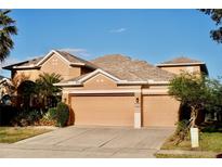 Two-story house with a three-car garage and landscaping at 6879 Remington View Ct, Orlando, FL 32829