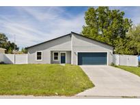 Charming single-story home features a well-manicured lawn, a two-car garage, and a classic white fence at 15033 Sw 35Th Cir, Ocala, FL 34473