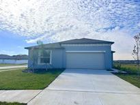Newly built home with a one car garage and a well-manicured lawn at 4514 Cozy Condor Ct, Bartow, FL 33830