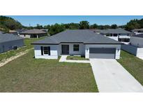A charming single-story home boasts a well-manicured lawn and a welcoming, modern facade at 105 Marion Oaks Manor, Ocala, FL 34473