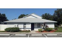 White single story home with blue door, landscaping, and parking at 12162 Graduate Dr, Orlando, FL 32826