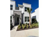 Two-story modern home with stone accents and landscaped entry at 1453 Serendipity Ln, Clermont, FL 34714