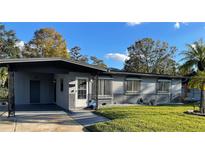 Ranch-style home with gray exterior, landscaping, and a carport at 1801 Hage Way, Orlando, FL 32805